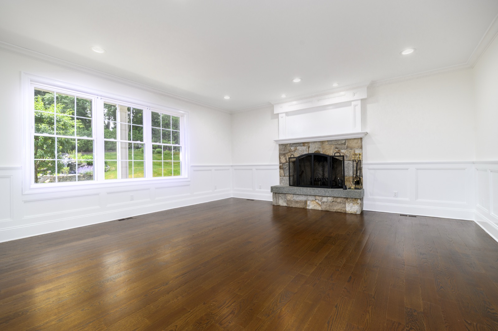 Empty Stamford CT family room with stone fireplace before virtual staging